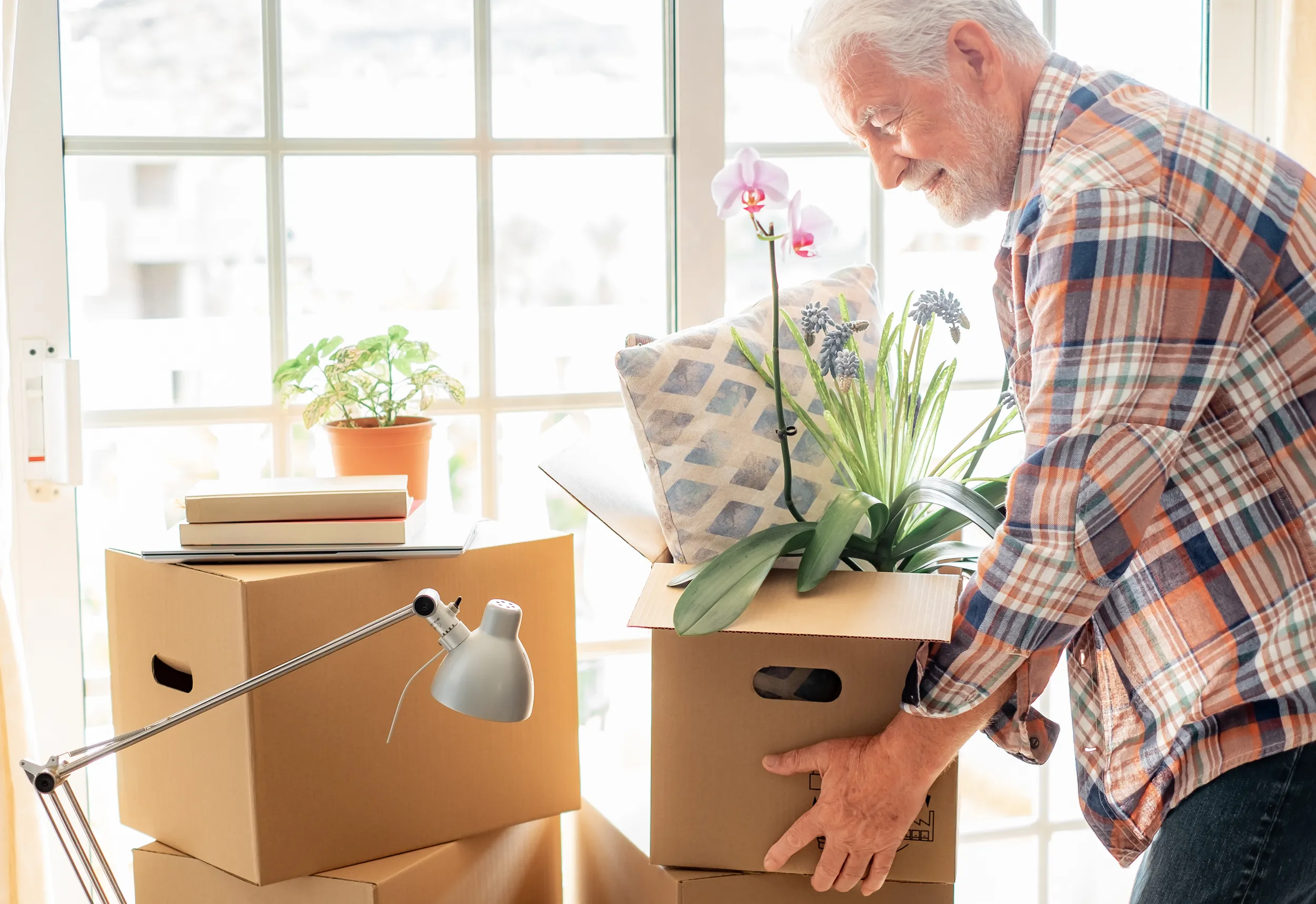 smiling handsome senior man holding cardboard box posing new house moving day concept relocating buying renting house apartment result