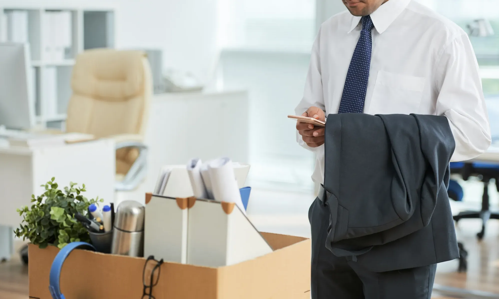 unrecognizable man standing office using smartphone with personal belongings box result 51dc4c8b